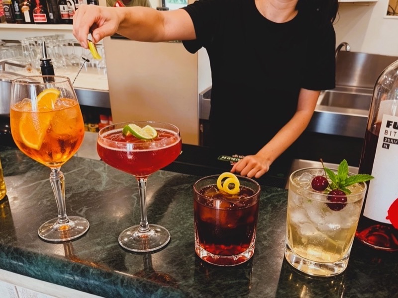 Il barista prepara spritz e cocktail al bancone per l'aperitivo